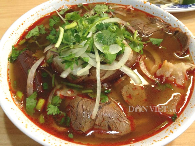 A bowl of bun bo Hue with required garnishes.